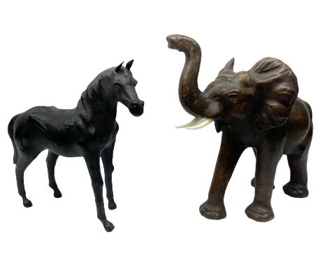 Liberty style dark leather clad model of an elephant, its trunk raised and in standing pose, together with a leather clad mod