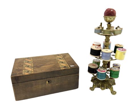 Victorian brass bobbin holder, with three tiers and pin cushion terminal, upon a foliate cast base with four paw feet, H29.5c