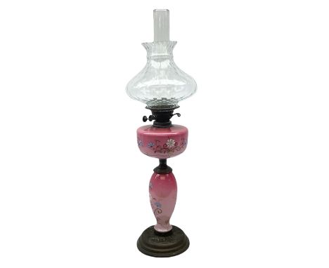 Pink opaline glass oil lamp of baluster form made with hand painted floral decoration upon a circular plinth, H80cm