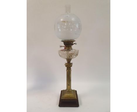 An oil lamp, with an acid etched glass shade, a clear glass well, on a brass base in the form of a Corinthian column, 77 cm h