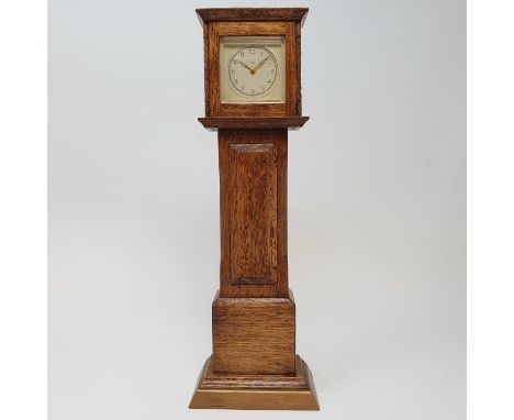 A timepiece, the 4.5 cm square dial in an oak case, in the form of a longcase clock, 29.5 cm high 