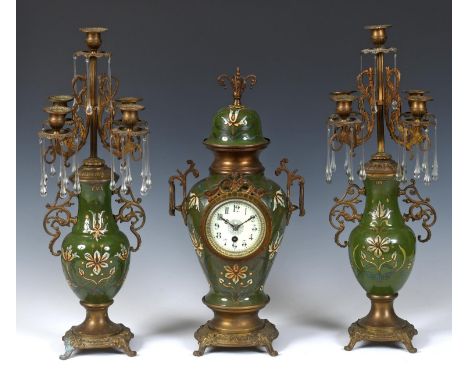 A clock garniture, the clock with an 8.5 cm diameter dial having Arabic numerals, in a pottery and gilt metal case, 49 cm hig
