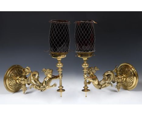 A pair of late 19th/early 20th century brass gas lamps, in the form of mermaids holding torches, with ruby glass shades, 33 c