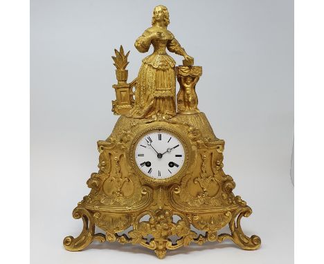 A late Victorian mantel clock, the 7.5 cm diameter enamel dial with Roman numerals, fitted an eight day movement, in a gilt b