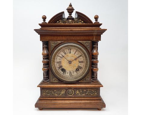 A mantel clock, the 11 cm diameter silvered dial with Roman numerals, in walnut case 33 cm high 