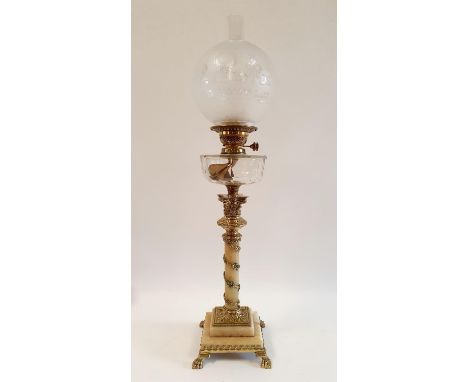 An oil lamp, with an acid etched blue glass shade, the base in the form of a vase decorated snakes and vine leaves, on square