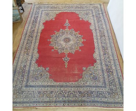 A Persian red ground carpet with multiple borders, centre with shaped medallion, 370 x 280 cm 