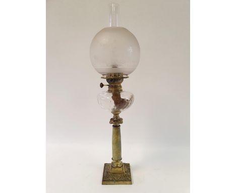 An oil lamp, with an acid etched glass shade, a clear glass well on brass and onyx base, 72 cm highSome rough edges to the ri
