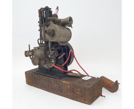 A small single cylinder petrol engine, with a pulley wheel, possibly for powering a toy motor launch, on a wooden base, 25 cm