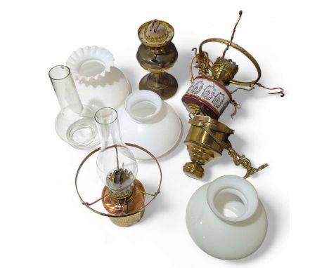 Three hanging oil lamps and a brass oil lamp with shades