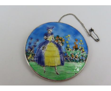 A silver and enamel brooch depicting a crinoline lady in a summer garden, partial hall mark, F J M & Co, 47mm diameter
