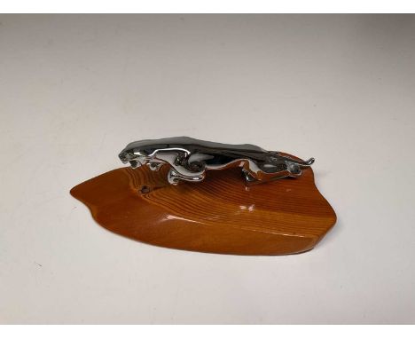 A vintage Jaguar motor car mascot mounted on a polished pitch pine shaped base, length 26cm. 
