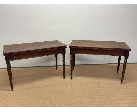 A pair of late George III mahogany rectangular fold over tables raised on ring turned tapering legs, width 114cm.