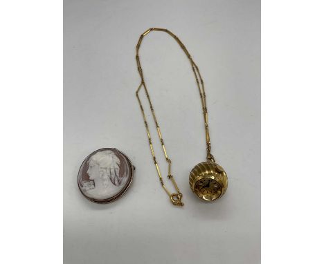 A circular cameo brooch depicting the profile portrait of a young woman in white metal frame, diameter 36mm, also a globe wat