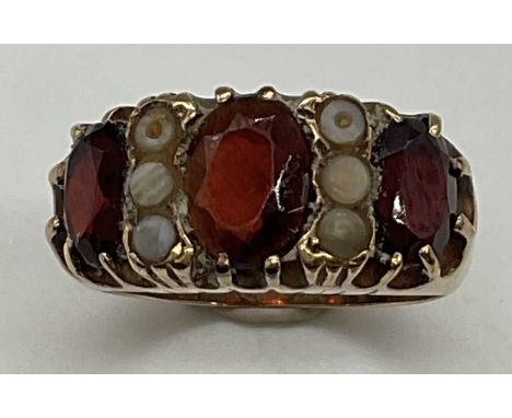 A 9ct yellow gold garnet set ring, size L, approx. 4.6g. Condition Report: Space between the garnets would appear to be small