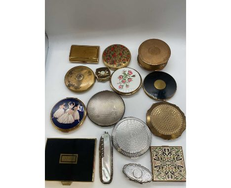 A group of compacts including a circular silver compact with engraved initials, a damaged pocket knife and two pill boxes.
