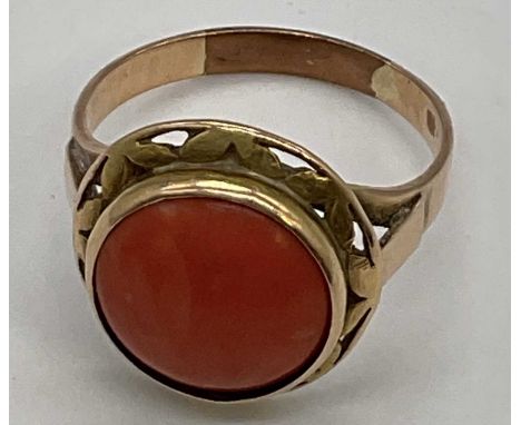 A yellow metal and coral cabochon set gentleman's ring with pierced frame, size W, approx. 6g. Condition Report: There has be