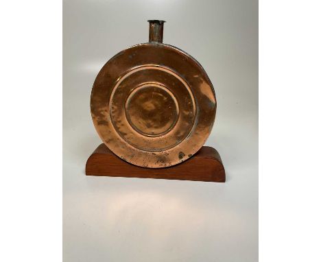 A decorative copper flask on wooden plinth, 34 x 29cm.