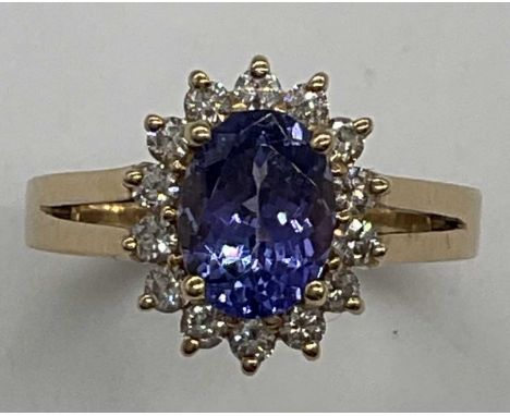 A 14ct yellow gold tanzanite and diamond oval cluster ring, size M1/2, approx. 3.6g. Condition Report: Presented in excellent
