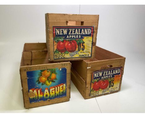 Three vintage wooden fruit crates with colourful labels.