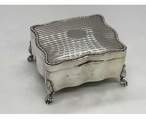NATHAN &amp; HAYES; a George V hallmarked silver trinket box of shaped rectangular form with engine turned decoration to the 