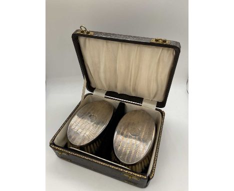 ROBERT PRINGLE &amp; SONS; a cased pair of George V hallmarked silver backed brushes with matching comb, engraved with initia