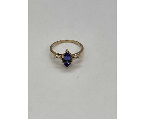 A 10ct yellow gold tanzanite and diamond ring, the boat shaped six claw set tanzanite flanked by twin diamonds to the shoulde
