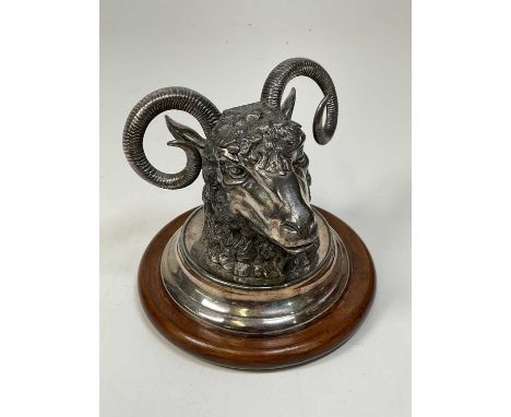 A Victorian silver plated ram's head inkwell, with rising cover enclosing a glass liner and mounted on a turned wooden base, 