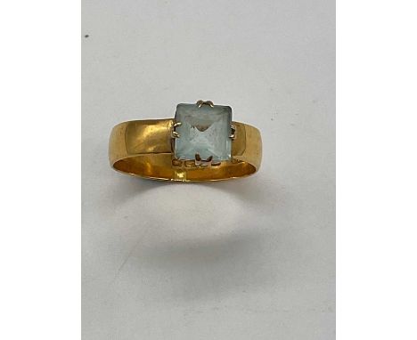 An 18ct broad yellow gold ring set with pale blue stone size Y1/2, approx. 6.3g.