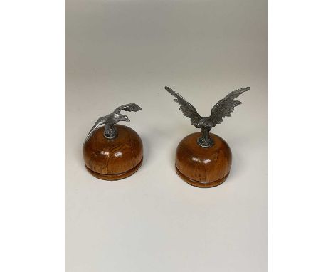 AFTER A.E. LEJEUNE; two eagle car mascots from vintage Alvis motor vehicles both mounted on polished domed wooden bases, heig