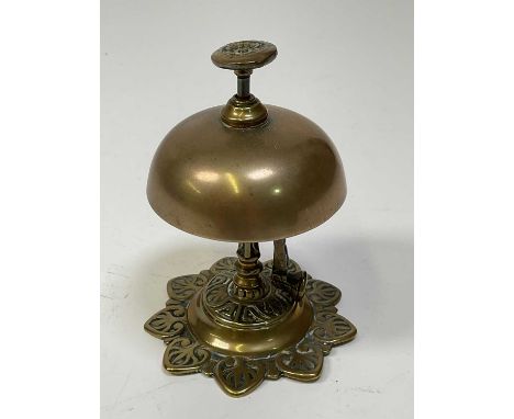 An early 20th century brass push button bell with rising hinged clapper striking on the exterior of the bell, height 13cm.