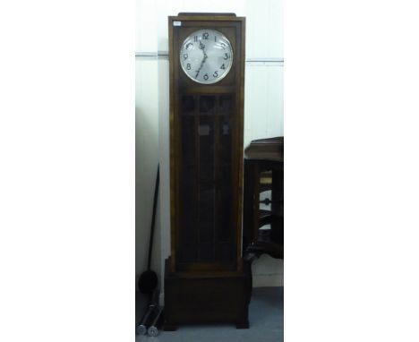 An early 20thC Continental oak longcase clock with a straight trunk and a glazed panelled pendulum door, on a box base; the w