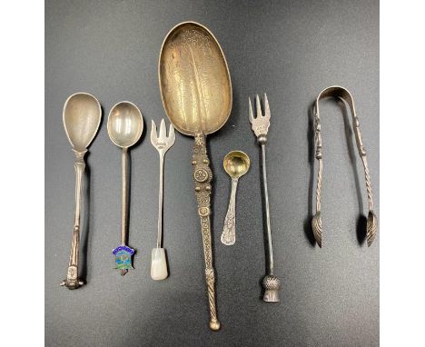 A selection of silver curios to include mustard spoons, shell sugar nips, pickle fork, and an ornate spoon hallmarked for Lon