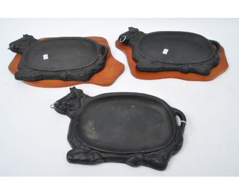 A series of three vintage 20th century cast metal decorative dishes moulded in the form of cows with ring to nose and two hav