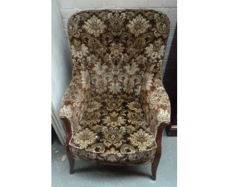 An armchair in brown floral print, 97cmH, with a wooden plate rack