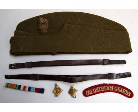 A green military private's hat with an embroidered lion insignia together with a strip of WW2 ribbons, a patch reading 'Colds