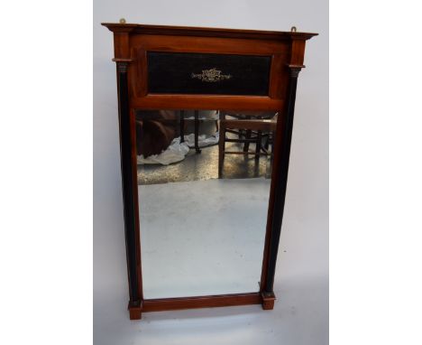 A wall hanging mirror with bevelled glass edge flanked by two corinthian columns
