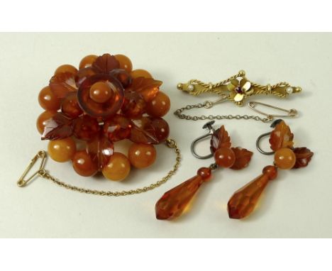 An amber floral brooch, formed as three circles of stones divided by one ring of leaves, with safety chain, and a pair of mat