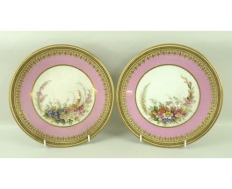 A pair of Royal Worcester porcelain plates, late 19th century, painted with floral central reserves, pink border and gilt dec