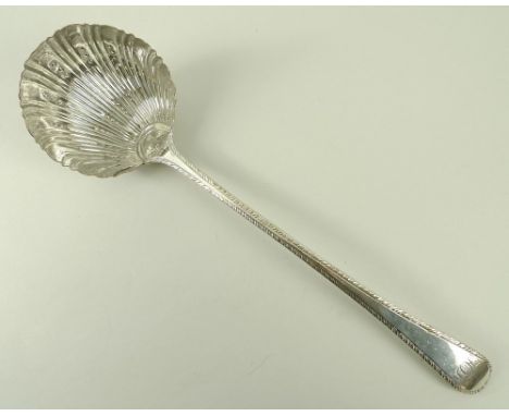 An early 19th century Old Sheffield plate soup ladle, with a shell cased bowl and feather edge to the Old English handle, mon