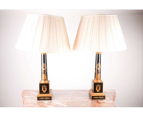 A pair of black toleware Doric column table lamps. Decorated with gilt neoclassical decoration, on a simple moulded and stepp