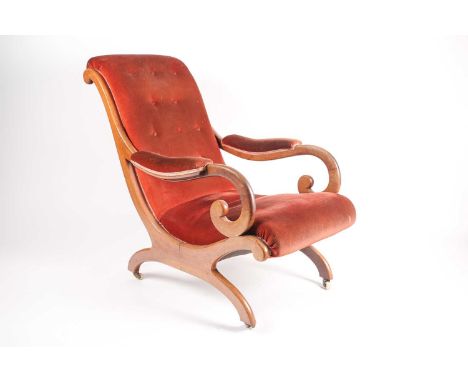 An early Victorian mahogany framed plantation-style open armchair with moulded and carved scroll back and "X" frame with red 