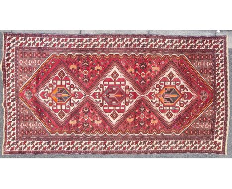 A 20th-century brick red ground Baktiari carpet in the Qashqai style with three diamonds on a pole. Within geometric borders 