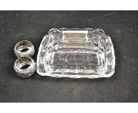 A cut glass butter dish with sterling silver handle, together with a pair of embossed silver napkin rings, Birmingham, maker 