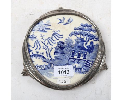 A silver plated teapot stand, on cast scrolled feet, with inset Willow pattern plaque 