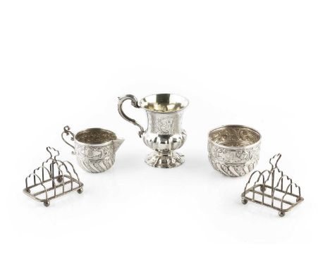 An Edwardian silver milk jug and matching sugar basin, embossed and engraved with stylised scrolling foliage, by Goldsmiths &