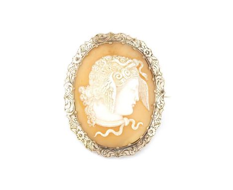 A 19th century cameo brooch, the oval shell cameo carved to depict the portrait profile of Medusa, to a shaped mount engraved