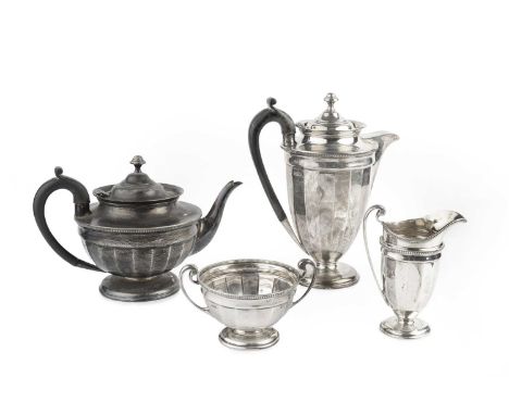 A George V silver four piece tea service, comprising teapot, and hot water pot, with ebonised handles, milk jug and sugar bas