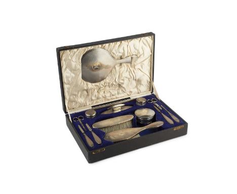 A George V silver dressing table set, with engine turned decoration, comprising circular trinket box, hand mirror, hair brush