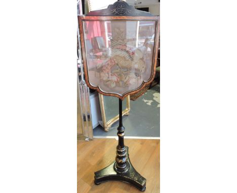 A mid Victorian papier mache polescreen, the arched birds eye maple framed banner in polychrome tapestry, depicting a bird of
